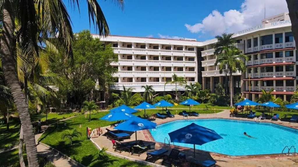 Resort building and pool with blue umbrellas